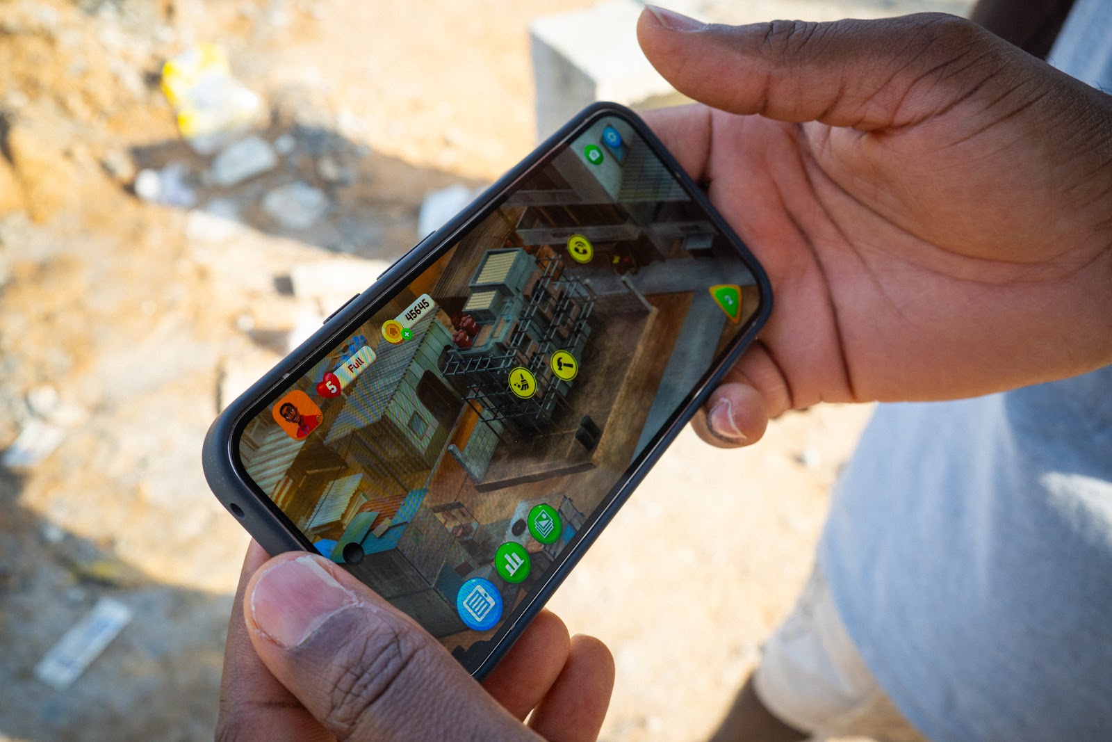 a user holds a mobile device with a Maliyo game on screen